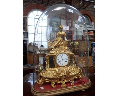A 19TH CENTURY FRENCH GILT SPELTER MANTEL CLOCK, decorated with a young woman under a (damaged) glass dome