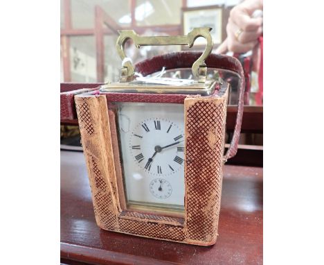 A BRASS CASED CARRIAGE CLOCK, the French movement with alarm, and leather carrying case