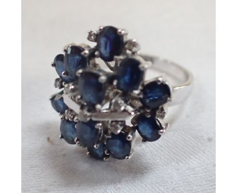 A SAPPHIRE AND DIAMOND CLUSTER RING, on a white gold shank stamped '585', ring size N-O