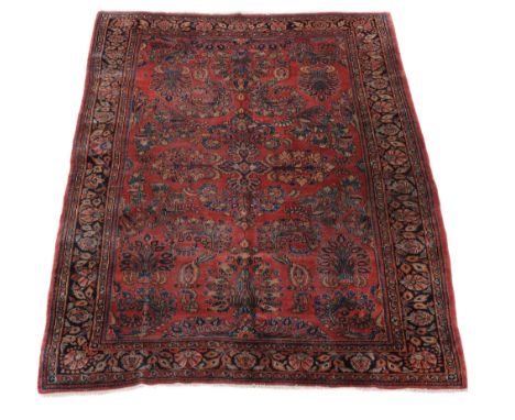  A Sarouk carpet,   the madder field decorated with polycrome foliate motifs, within multiple borders,    approximately 272 x