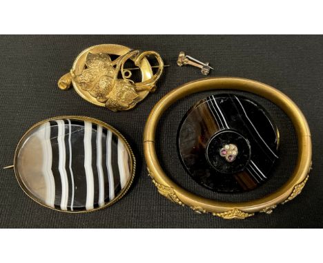A Victorian seed pearl and amethyst set rolled gold hinge bangle, banded agate shield brooch, another oval, yellow metal scro