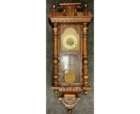 A 20th century mahogany Vienna wall clock; enamel face, Roman numerals, includes pendulum and key. 