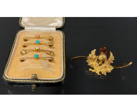 A Scottish Thistle bar brooch, orange citrine top, serpentine shaped bar, 9ct gold mounts, base metal pin, faint marks, Chest