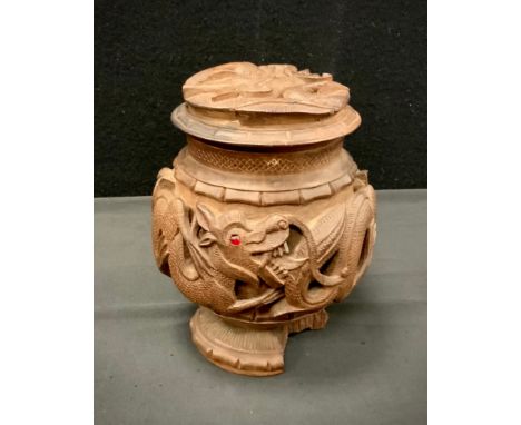 Anglo Indian carved hardwood coconut shape tea caddy, carved with an interlocking band of dragons, dragon mask cover, red gla