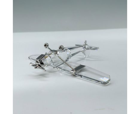 A clear crystal figure of an antique aircraft that is decorated with rhodium accents for the propeller, wheels, and struts. S