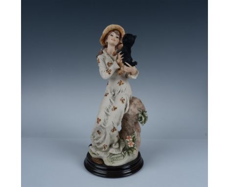 Handcrafted figurine featuring a graceful woman in a beautifully draped gown holding a detailed Yorkshire Terrier. Sculpture 