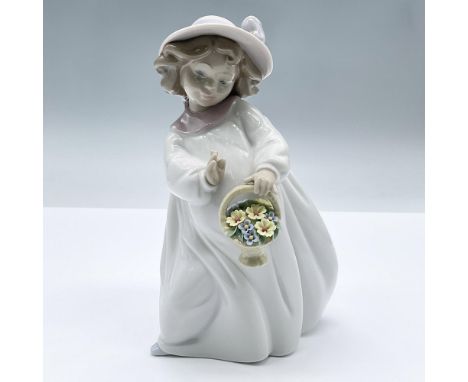 Adorable glossy figure of a girl in a white dress holding a basket of flowers. This item has its original box measuring 8.75"