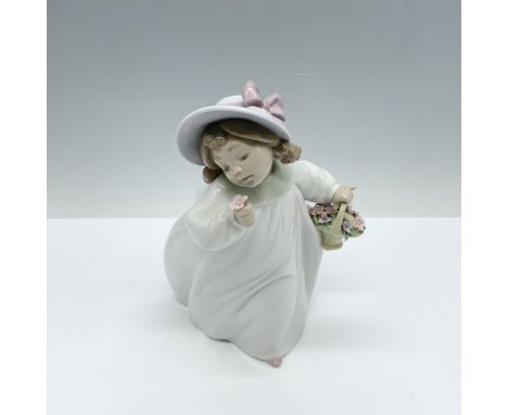 Glossy figure of a young girl in a white flowy dress carrying a basket of flowers in one hand and a singular flower that she 