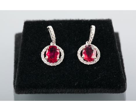 PAIR OF RUBY AND DIAMOND EARRINGS
each formed by an oval ruby of approximately 0.85 carats surrounded by diamonds suspended f