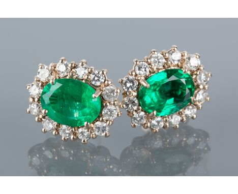 PAIR OF EMERALD AND DIAMOND EARRINGS
the oval emeralds each in a surround of twelve brilliant cut diamonds, hallmarked for ei