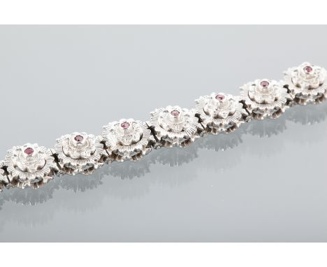 MID TWENTIETH CENTURY EIGHTEEN CARAT WHITE GOLD RUBY SET BRACELET
with tiered textured circular links, each set with a a cent