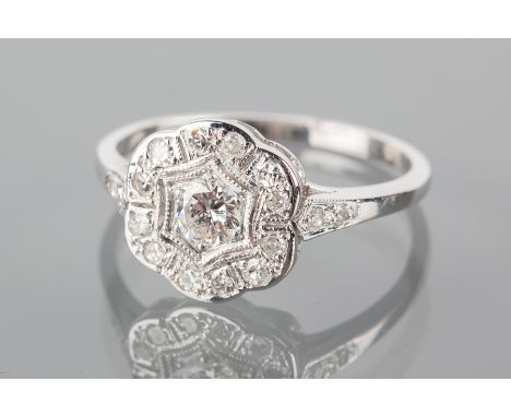 EARLY TWENTIETH CENTURY DIAMOND CLUSTER RING
the bezel of floral form, pierced and set with a central brilliant cut diamond o