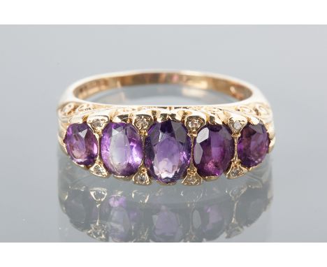 VICTORIAN STYLE  AMETHYST DRESS RING
set with five graduated oval amethysts in a boat shaped setting, with scrolling decorati