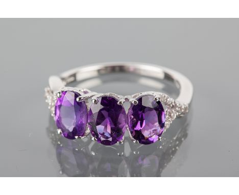 AMETHYST DRESS RING
set with three oval amethysts each 8mm long, on birfurcated white gem set shoulders, in silver