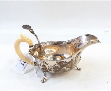 Silver sauce boat with ivory handle, maker's mark 'EV' and a silver ladle with sunflower-shaped handle (2) 