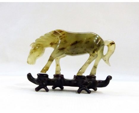 Oriental carved jade model of a horse,13 cms long, on carved hardwood stand