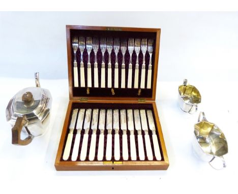 Silver plated three-piece tea service, all panelled and set of 12 cream-handled fish knives and forks in stained wood table-t