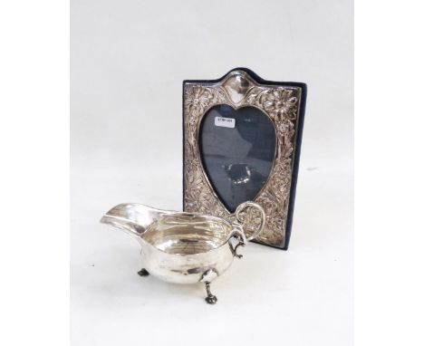 Modern silver photograph frame decorated with flowerhead around a central heart-shaped aperture with easel support, 20cm high