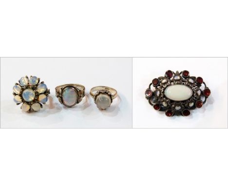 Moonstone set ring, a costume brooch set opals and garnets, a silver ring set opal doublet, a silver-coloured ring set moonst