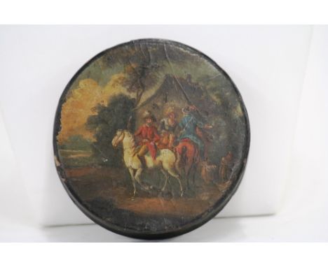 A 19th Century circular papier mache snuff box, the lid decorated in the Dutch style, with figures outside of a Country Inn