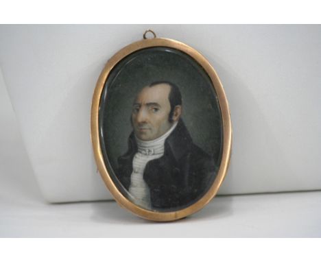 A Georgian miniature portrait on ivory, of a gentleman wearing frock coat, in oval yellow metal frame, 7cm x 5.1cm in extreme