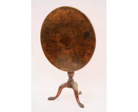 A Georgian oak circular tilt top occasional table, raised on baluster turned column and tripod base, 76cm dia.