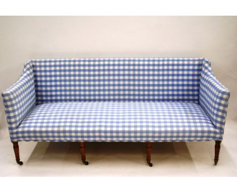 A Georgian mahogany four seater settee, raised on ring turned front supports terminating in brass caps and castors, 181cm lon