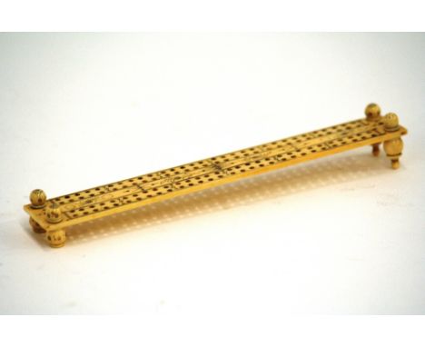 An ivory cribbage board, with pin prick decoration, 18.5cm long