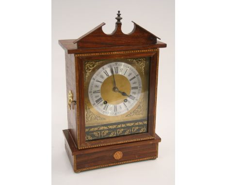 A walnut and inlaid cased mantel clock, the 8 day movement striking on a gong, 47cm high x 28.5cm wide