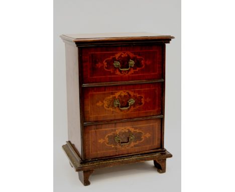 A 19th Century continental walnut and marquetry decorated cupboard, enclosed by a triple dummy drawer panel, raised on a cush