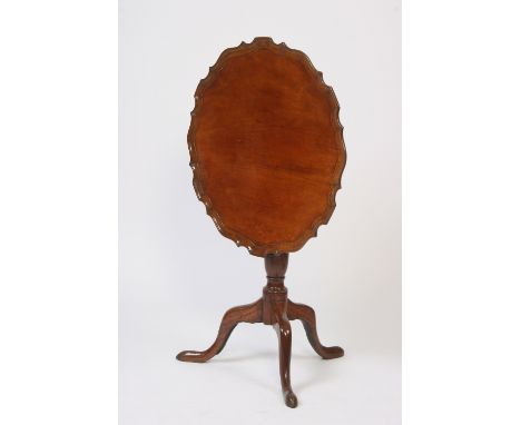 A Georgian mahogany pie crust bordered snap top occasional table, raised on a baluster turned column and tripod base, 68.5cm 