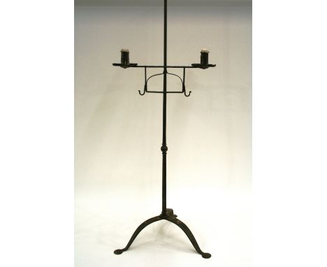 An antique ironwork adjustable twin branch candle holder, raised on tripod base and petal feet, 143cm high