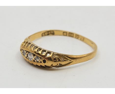 An 18ct. gold three stone diamond ring, set old cut diamond to centre flanked by smaller eight-cut diamond to either side abo