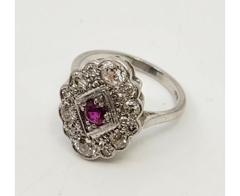 An 18ct. white gold, diamond and ruby ring, in the Art Deco style, having lobed oval mount set mixed round cut ruby within lo