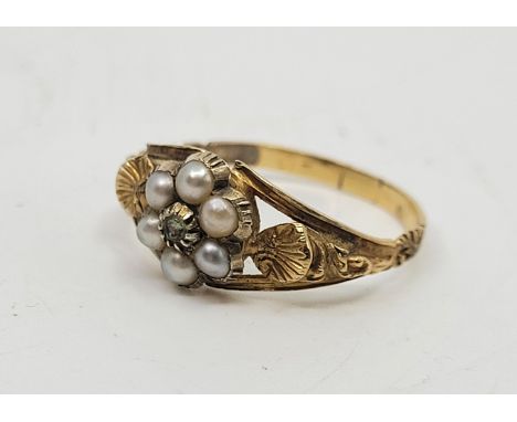 A precious yellow metal pearl and green gemstone ring, claw set mixed light green gemstone (possibly peridot) to raised centr