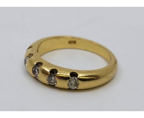 An 18ct. gold and five stone diamond ring, flush set five round brilliant cut diamonds (ETDW 0.35 carats, one diamond chipped