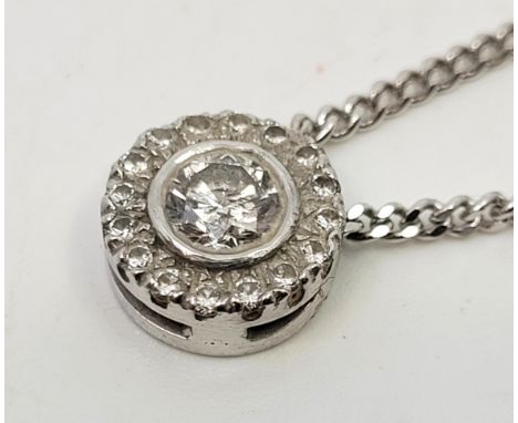 A 9ct. white gold diamond pendant necklace, the circular pendant set central round brilliant cut diamond (centre stone EDW 0.