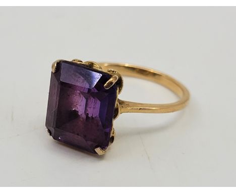 A precious yellow metal and amethyst cocktail ring, set mixed rectangular cut amethyst (yellow metal assessed as 18ct. gold),