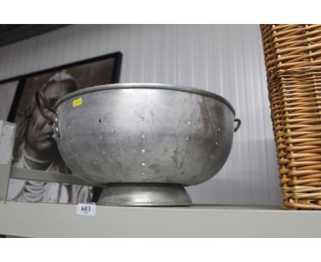 A large metal vintage colander