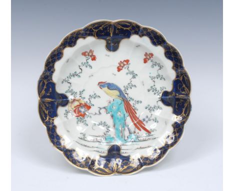 A Worcester Sir Joshua Reynolds pattern  shaped circular plate, decorated with a long tailed bird perched on a rock in brilli
