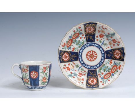 A Worcester Rich Queens pattern fluted coffee cup and associated saucer, grooved handle, decorated with alternating panels of