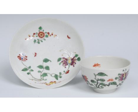 A Worcester Hibiscus pattern tea bowl and saucer, decorated with sacred scroll, large honeysuckle flower, trailing vines and 