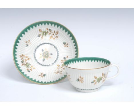 A Worcester fluted teacup and saucer, decorated with formal scattered floral sprigs in two tones of green, with gilt foliage,