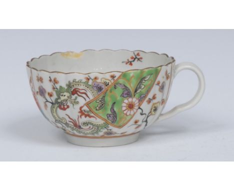 A  Worcester Brocade pattern  fluted teacup, with  ear shaped handle, decorated with  panels of dragons, flowering prunus, mo