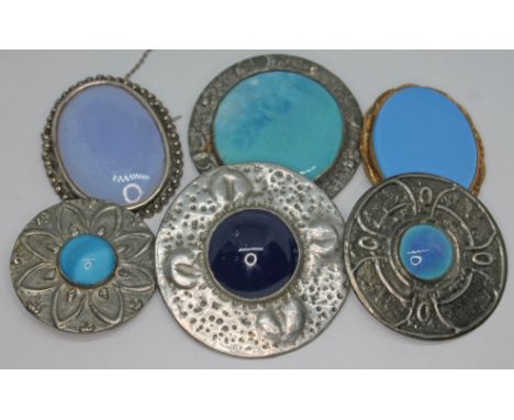 A group of six white metal brooches including Arts &amp; Crafts target brooches, Celtic style etc.  