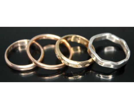 A group of four rings comprising two hallmarked 9ct gold wedding bands, a hallmarked 9ct gold eternity ring and a hallmarked 