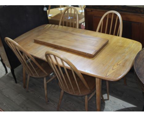 An Ercol blonde elm extending dining table and four spindle back chairs, max. table length 227cm, width 83cm.  Condition: tab