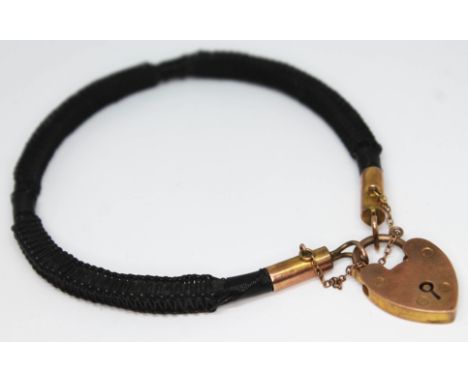 A wire bangle with heart shaped lock marked '9c', the lock weighing approx. 4g.  