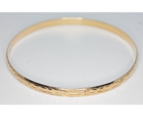 A hallmarked 9ct gold engraved bangle, diam. 67mm, wt. 10.09g.  Condition - good, no damage/repair, minor wear only.