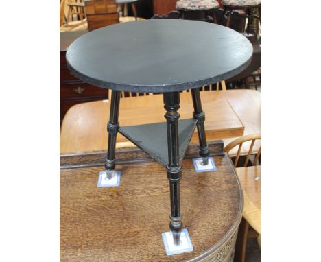 A Victorian parcel gilt and ebonised gypsy style table, labelled 'From T.H. Filmer &amp; Sons...', height 63cm, diam. 55cm.  